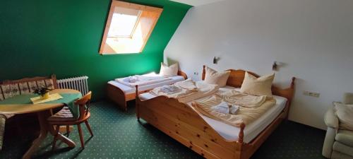 a bedroom with two beds and a table and a window at Landgasthaus Backhof-Helmle in Breitnau
