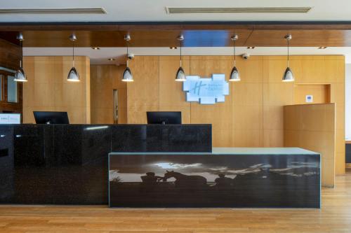 a black desk with a picture of people on it at Holiday Inn Express London - Epsom Downs by IHG in Epsom