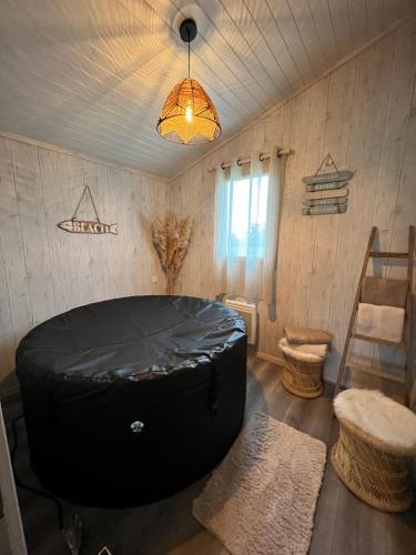 une pièce avec une grande baignoire noire dans le coin d'une pièce dans l'établissement Camping La Tourelle, à Plémy