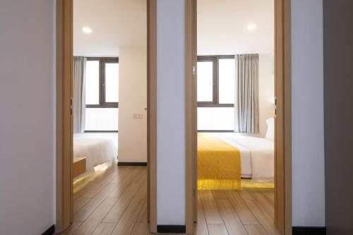 a room with two beds and a bedroom with a mirror at Amanda Hotel堆谷里酒店 in Phnom Penh