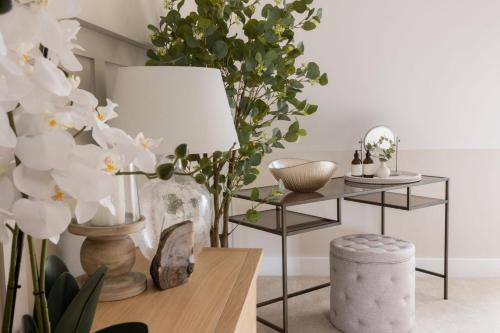 a living room with white flowers and a table with a lamp at Stylish 3BD Townhouse in Central Winchester in Winchester