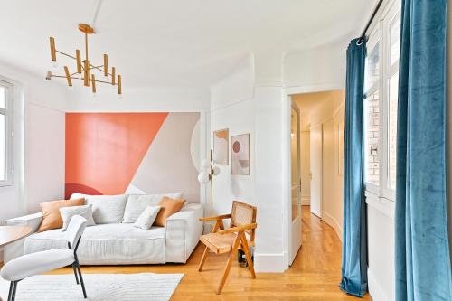 - un salon avec un canapé blanc et des rideaux bleus dans l'établissement Appartement Arc de Triomphe - Neuilly - II, à Neuilly-sur-Seine