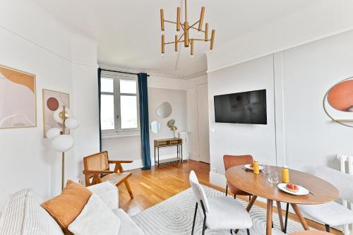 un salon avec une table et des chaises dans l'établissement Appartement Arc de Triomphe - Neuilly - II, à Neuilly-sur-Seine