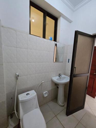 a bathroom with a toilet and a sink at Tulivu Urban - Twiga Hotel in Moshi