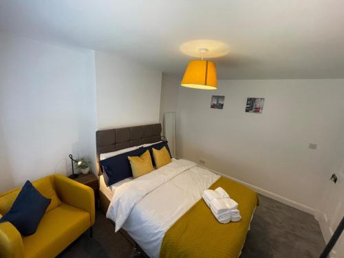 una camera con un letto e un divano giallo di Cozy, Spacious 2BD House in Historic Chapelfields a Spon End