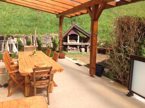 une table et des chaises en bois sur une terrasse dans l'établissement Gîte Des Fruitiers, à Orbey