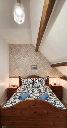 - une chambre avec un grand lit en bois et des oreillers bleus dans l'établissement Les Hortensias à ST GILLES VIEUX MARCHE WIFI NETFLIX CALME, à Saint-Gilles-du-Vieux-Marché