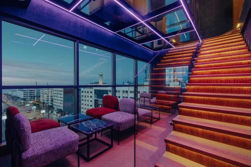 a bar with stairs and chairs and a view of a city at Exe Casablanca in Casablanca