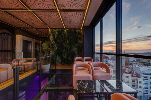 a room with chairs and a glass table with a view at Exe Casablanca in Casablanca