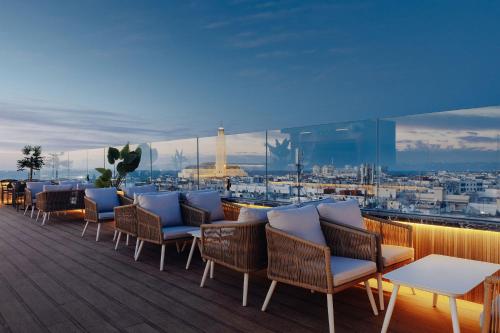a rooftop deck with chairs and a view of a city at Exe Casablanca in Casablanca