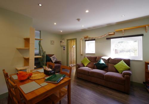 a living room with a couch and a table at Fun holiday lodges in historic walled garden near Falkirk, Heart of Scotland Holidays in Falkirk