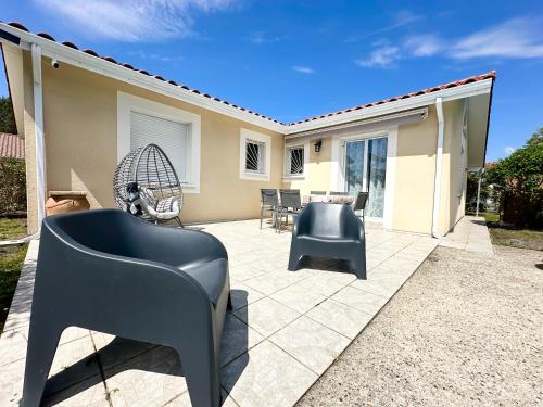 une terrasse avec une chaise, une table et des chaises dans l'établissement Villa SANBIAS - Maison avec piscine 7km de l'Océan, à Bias