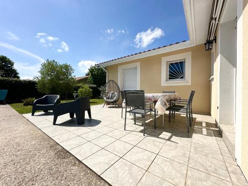 une terrasse avec des chaises et une table dans une maison dans l'établissement Villa SANBIAS - Maison avec piscine 7km de l'Océan, à Bias