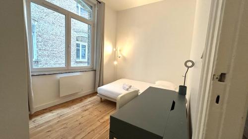 Cette chambre blanche dispose d'un bureau et d'une fenêtre. dans l'établissement Charlotte - Grand T4 à 5 Mn à pieds gare TGV, à Lille