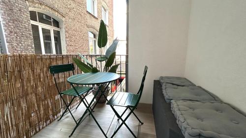 - un balcon avec une table, des chaises et un lit dans l'établissement Charlotte - Grand T4 à 5 Mn à pieds gare TGV, à Lille
