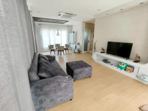 ein Wohnzimmer mit Couch und Flachbildfernseher in der Unterkunft The Lanna Lagoon เดอะลานนา ลากูน in Chiang Mai