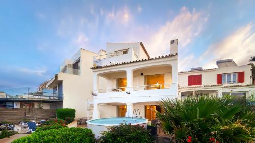 a white house with a swimming pool in front of it at Beira Mar by Check-in Portugal in Albufeira