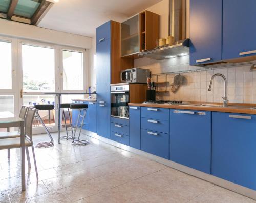 a kitchen with blue cabinets and a table with chairs at KG Lierna Lake View in Lierna