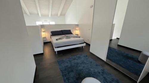 a bedroom with a bed and two blue rugs at Elegant loft by the sea in Punta Marina