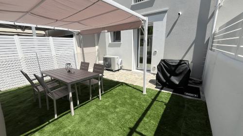 a patio with a table and chairs under a canopy at Elegant loft by the sea in Punta Marina