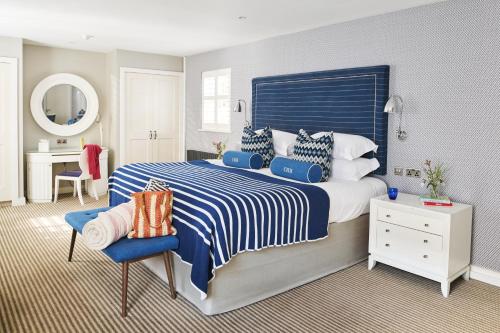 a bedroom with a blue and white bed and a desk at Harbour Hotel & Spa Christchurch in Christchurch