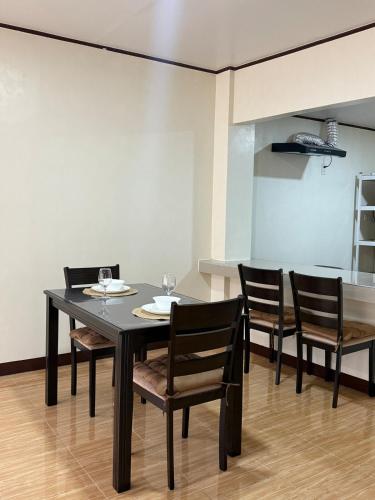 a dining room with a black table and chairs at Casita del Mabini in Mabini