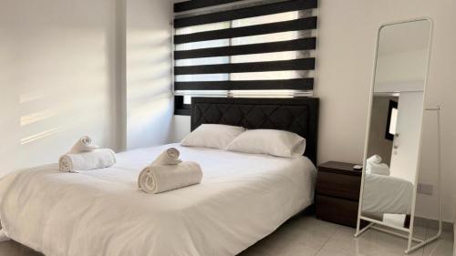 a bedroom with a white bed with towels on it at Modern One-Bedroom Suite with Balcony in Central Nicosia in Nicosia