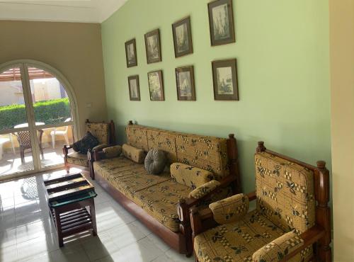 a living room with a couch and pictures on the wall at Location Maison en bord de mer, Nord Egypte in El Hamam