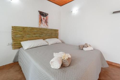 a bedroom with a bed with towels on it at Ittiturismo Isola Rossa L'agrumeto in Teulada