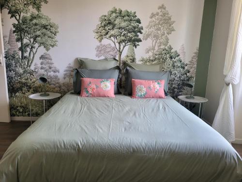 a bedroom with a large bed with pink pillows at L'Annexe de Steph in Loulans-Verchamp