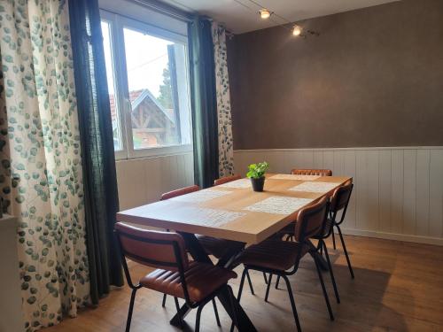a dining room table with chairs and a large window at L'Annexe de Steph in Loulans-Verchamp