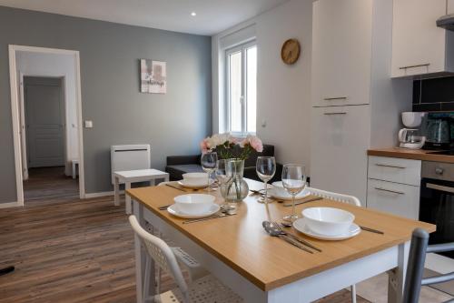 une cuisine et une salle à manger avec une table et des verres à vin dans l'établissement Budget apart downtown with parking, à Charleville-Mézières