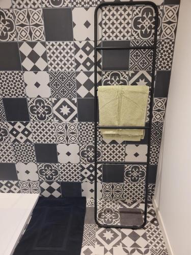 a bathroom with black and white tiles on the wall at L'Annexe de Steph in Loulans-Verchamp