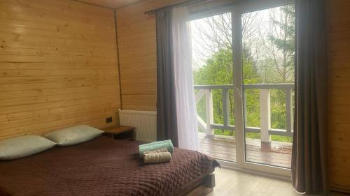 a bedroom with a bed and a large window at Шпінь 4 in Vorokhta