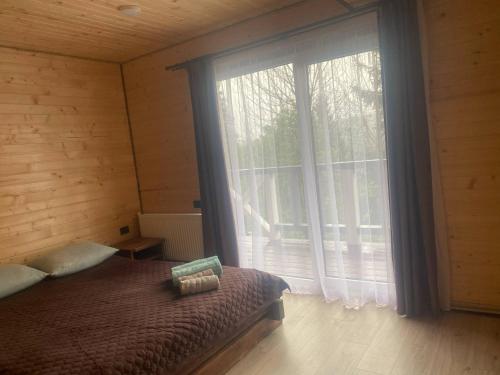a bedroom with a bed and a large window at Шпінь 4 in Vorokhta