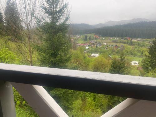 a balcony with a view of a town and trees at Шпінь 4 in Vorokhta