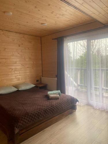 a bedroom with a bed and a large window at Шпінь 4 in Vorokhta