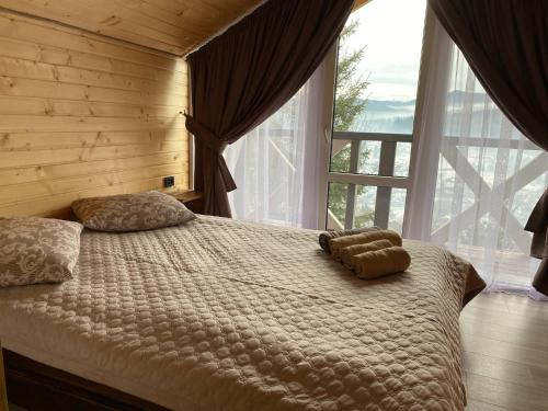 a bedroom with a large bed with a large window at Шпінь 4 in Vorokhta