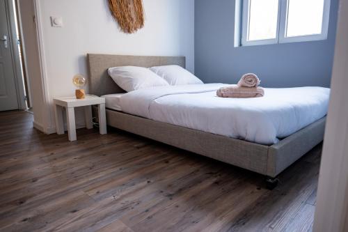 une chambre avec un grand lit avec un plancher en bois dans l'établissement Budget apart downtown with parking, à Charleville-Mézières