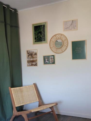 a room with a chair and pictures on the wall at L'Annexe de Steph in Loulans-Verchamp