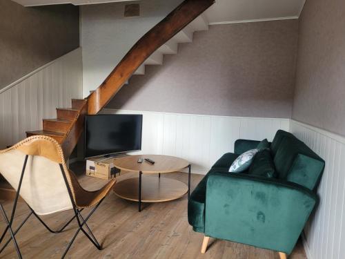 a living room with a green couch and a table at L'Annexe de Steph in Loulans-Verchamp