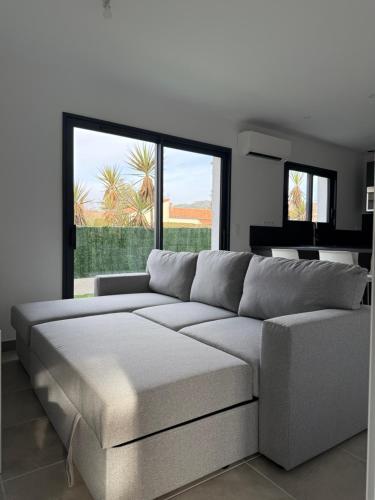 un salon avec un canapé et une grande fenêtre dans l'établissement Les gîtes de mamie, à Saint-Martin-dʼArdèche