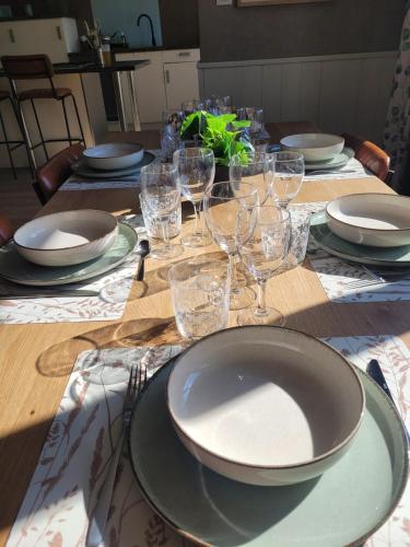 a table with plates and wine glasses on it at L'Annexe de Steph in Loulans-Verchamp
