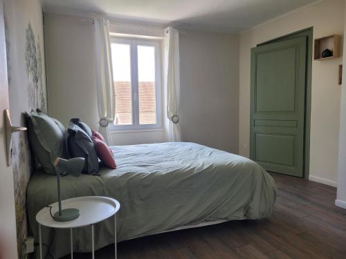 a bedroom with a bed and a table and a window at L'Annexe de Steph in Loulans-Verchamp