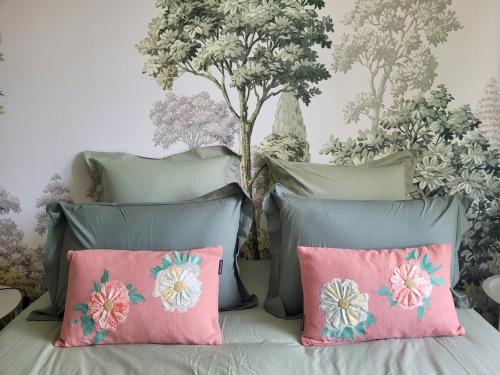 a bedroom with a bed with pink and blue pillows at L'Annexe de Steph in Loulans-Verchamp