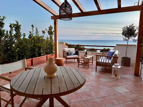 a patio with a table and chairs and the ocean at Casa Barca - Luxury Apartment in Agrigento