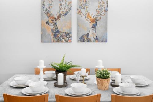 a dining room with a table with chairs and two deer paintings at Designer Darlinghurst Retreat Garage Parking in Sydney