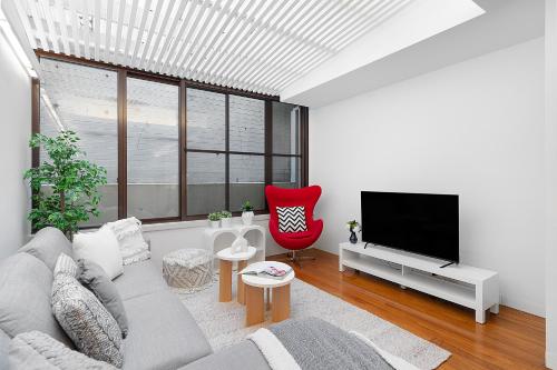 a living room with a couch and a flat screen tv at Designer Darlinghurst Retreat Garage Parking in Sydney