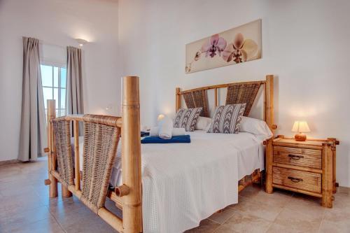 a bedroom with a large bed and a night stand at Ca na Margalida in Manacor