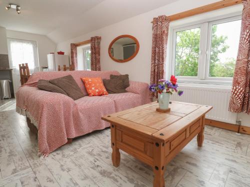 a living room with a couch and a table at Sea View Loft in Penzance